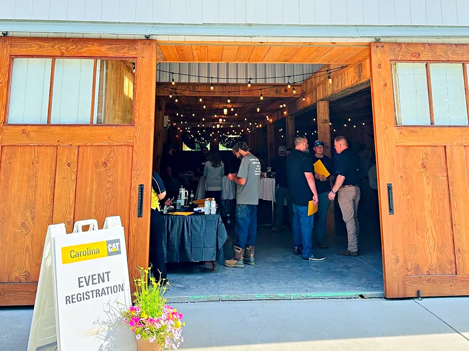 Guests checking in at a registration table inside the open barn doors